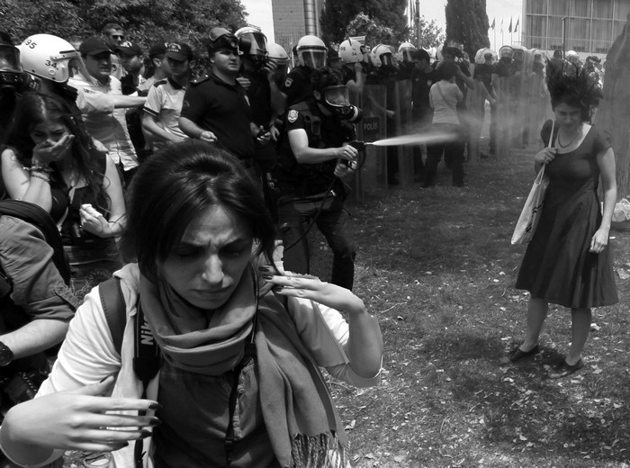 Turkish riot policeman uses tear gas during a protest in central Istanbul